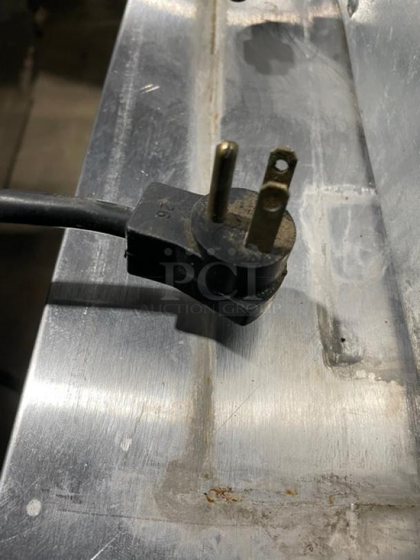 Beverage-Air UCR27A commercial undercounter refrigerator plug on stainless steel surface, 115V.