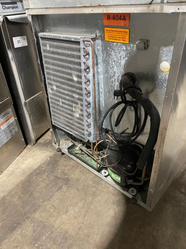 Delfield Model 406CA-DHL-DD1 stainless steel undercounter refrigerator with visible internal components and R-404A refrigerant label.