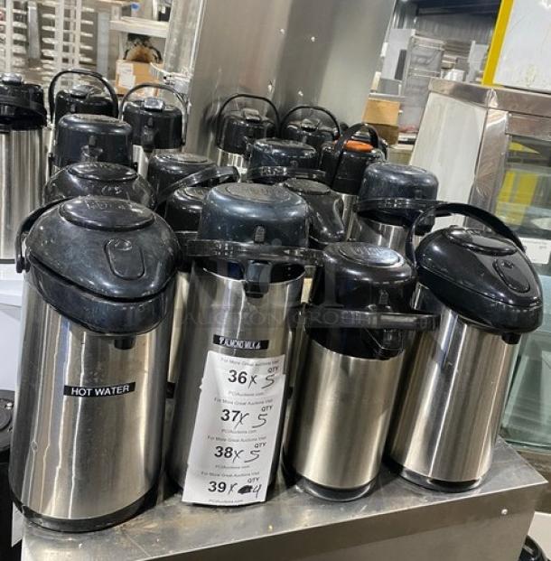 Stainless steel insulated beverage dispensers, commercial grade, multiple units. Features "HOT WATER" label, good condition.