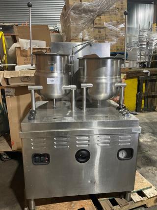 Market Forge stainless steel double tilting soup kettle, natural gas-powered, on legs, used condition, functional when removed.