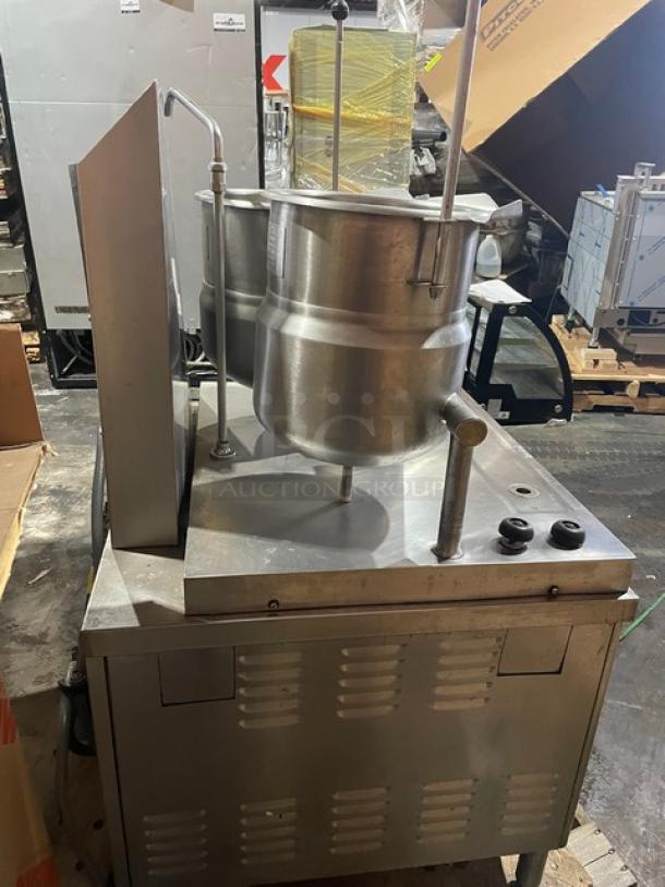 Market Forge commercial stainless steel double tilting soup kettle, natural gas-powered, on legs, working condition.
