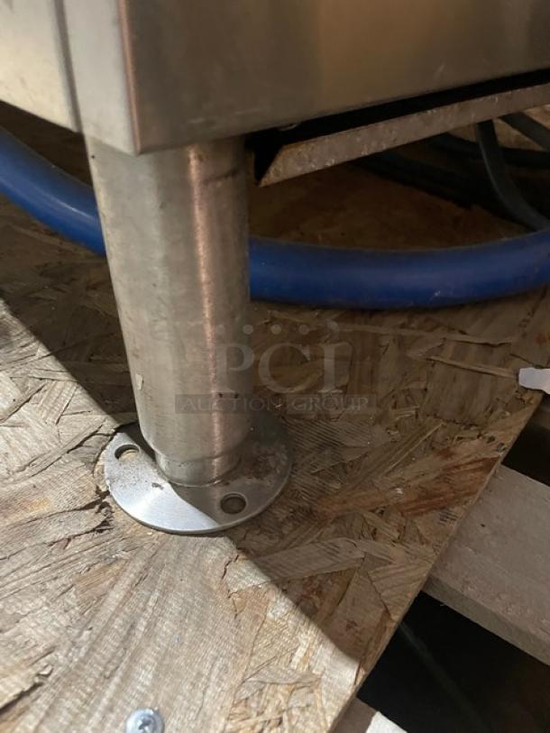 Market Forge stainless steel natural gas tilting soup kettle on legs, shown mounted on a wooden surface, in working condition.