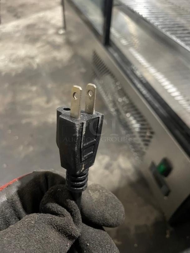 Marchia Model MDC201 refrigerated display case with curved glass and wired rack. Features shown with power plug detail.