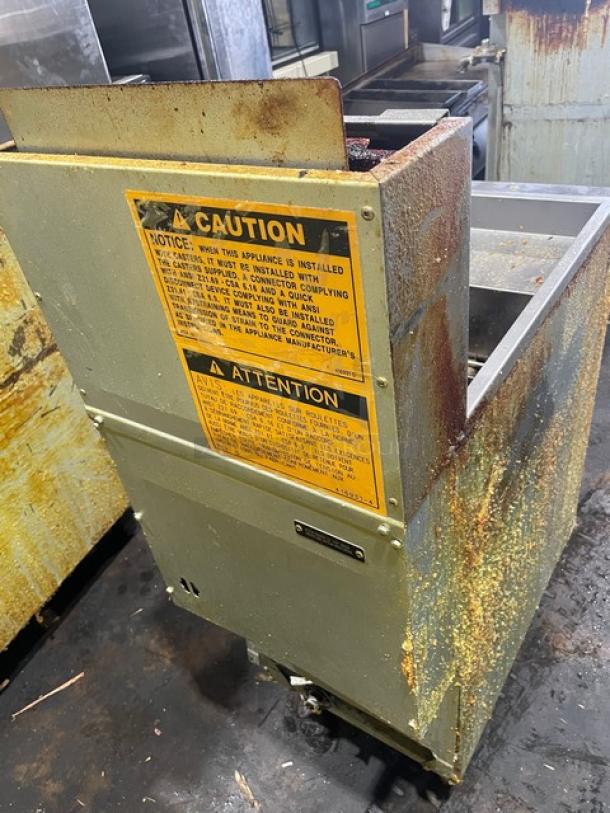 Vulcan Veg Series stainless steel deep fat fryer, model 1VEG50M-1, natural gas, with backsplash, basket hanger, on legs, visible wear.