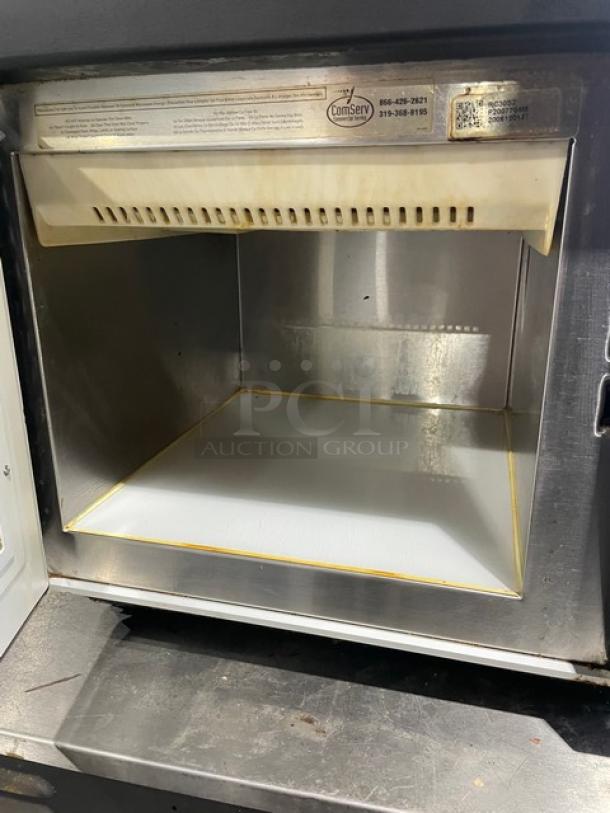 Amana RC30S2 commercial countertop microwave with stainless steel interior, programmable touchpad controls. Slight wear visible.