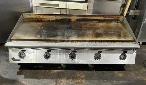 Star Ultra Max stainless steel flat griddle, natural gas-powered, on legs, used condition, with 5 control knobs visible.