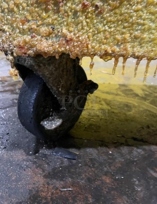 Frymaster PMJ135SD fryer wheel, slightly worn, attached to fryer base, functional when removed.