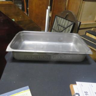 Full-size stainless steel hotel pan, 4-inch deep, good condition, on display table.