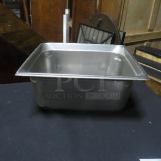 One half-size, 6-inch deep hotel pan, stainless steel, good condition, ideal for catering or food service use.