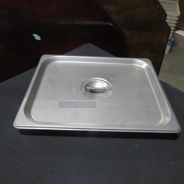 New 1/2 size hotel lid, stainless steel, with handle; model 2XBID; perfect condition, no visible markings.
