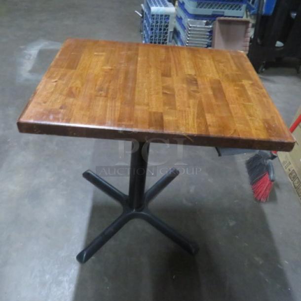Solid wooden table top on pedestal base, dimensions 30x24x29 inches, features sturdy construction and natural wood finish.
