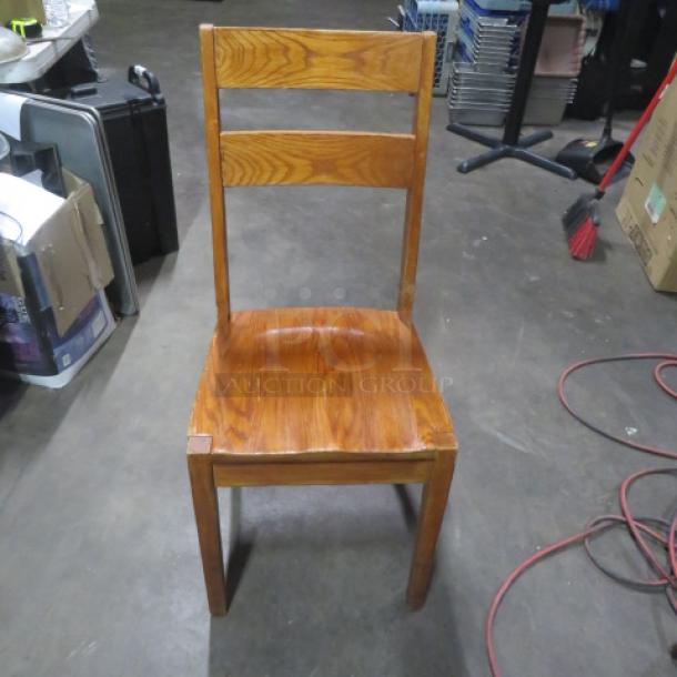 Solid wooden chair with tall back, natural finish, minor wear. Ideal for dining or accent. No visible tags or labels.