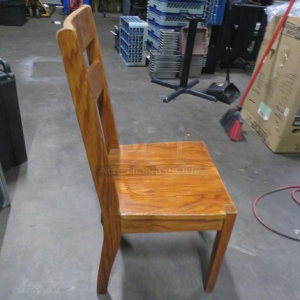 Solid wooden chair with tall back, rich brown finish, sturdy condition, featuring horizontal slat design on backrest.