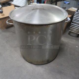 XXL stainless steel stock pot with lid, 21x20 inches. Some surface wear visible. Ideal for large-scale cooking.