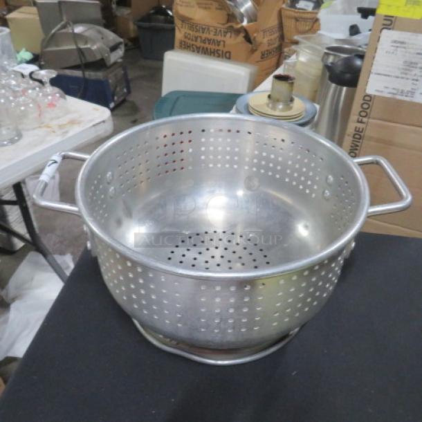 12-inch aluminum colander with handles, used condition. Perforated for draining, ideal for kitchen use.