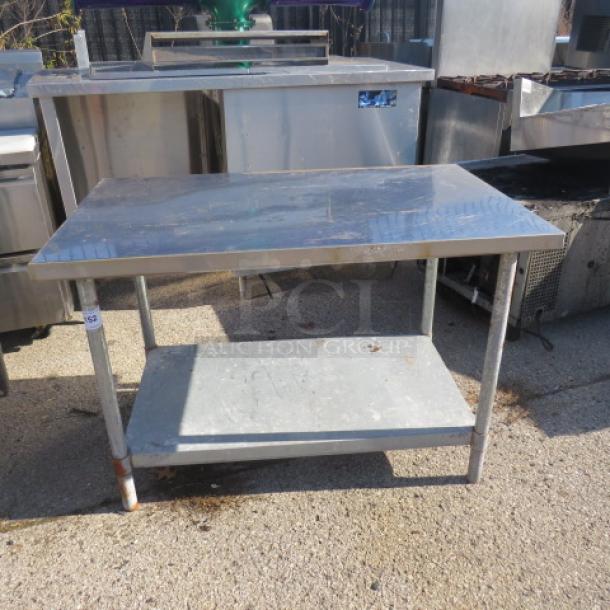Stainless steel table with under shelf, dimensions 48x30x32.5 inches, in used condition, ideal for kitchen or workspace.