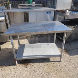 Stainless steel table with under shelf, dimensions 48x30x32.5 inches, in used condition, ideal for kitchen or workspace.