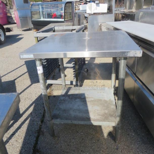 Stainless steel table with under shelf, 30x30x34 inches. Used condition, sturdy, ideal for kitchen or workshop use.
