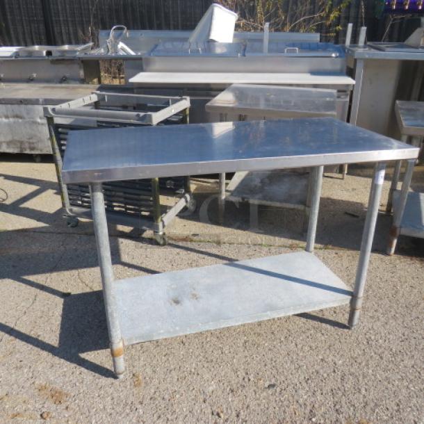 Stainless steel table with under shelf, 49x24x35 inches. Good condition, sturdy construction. Ideal for industrial use.