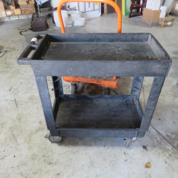 Black 2-shelf utility cart on casters, 34x17.5x33 inches, worn condition, sturdy design, ideal for storage and transport.