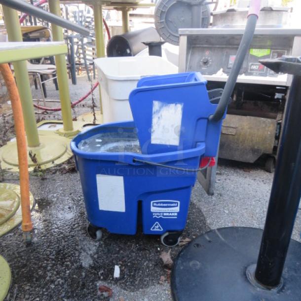 Rubbermaid mop bucket with wringer, blue plastic, on wheels, used condition. Labels indicate Rubbermaid WaveBrake model.