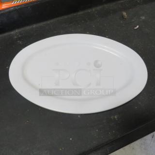 13.5x9.5 white poly platter, used, oval shape, minor surface marks, suitable for serving or display.