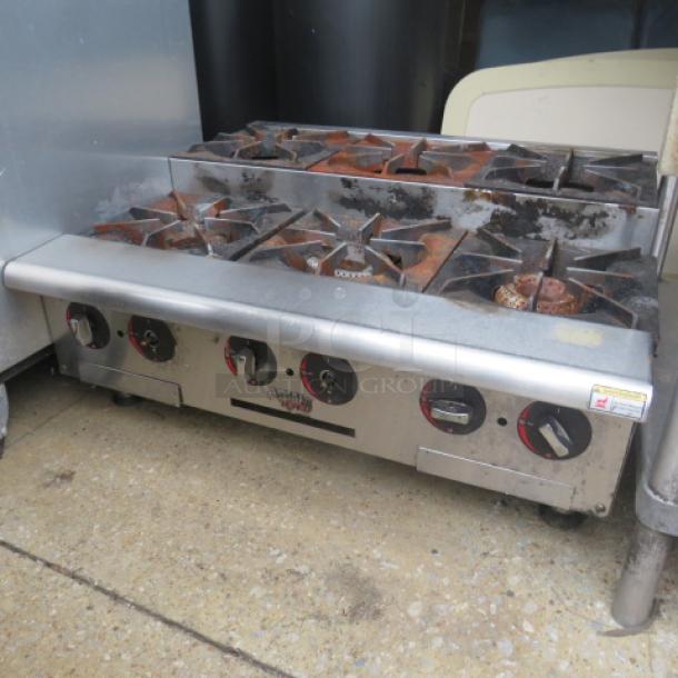 APW WYOTT Natural Gas Tabletop 6 Burner Range, 36x32x16, used condition, visible knobs, stainless steel finish.