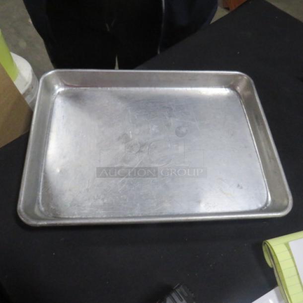 1/4 Size Sheet Pan, 5XBID, metal, lightly scratched, used condition, rectangular with raised edges.