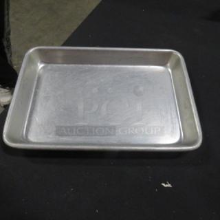 9.5x7 inch sheet pan, aluminum, used condition, visible surface scratches, plain design, no visible labels or markings.