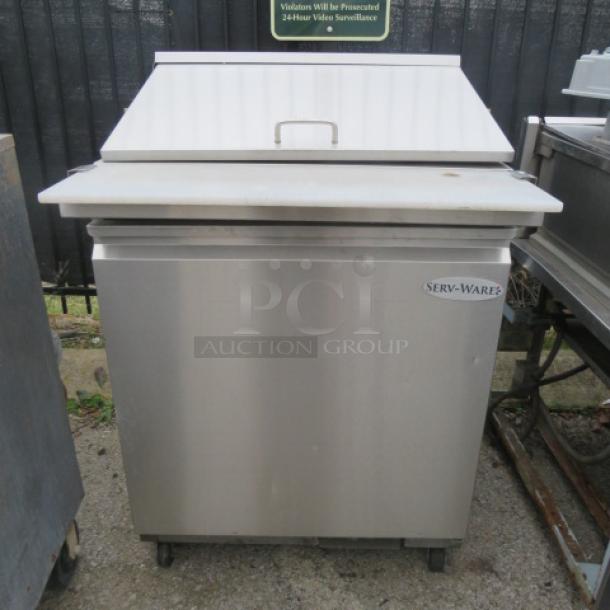 Servware SP29-12M one-door refrigerated prep table with cutting board, rack, on casters, 115V, 30x34.5x43.5, stainless steel.