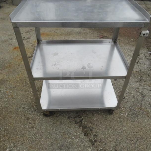 Stainless steel 3-shelf cart on casters, 24x16x32 inches. Features sturdy construction and easy mobility. Used condition.