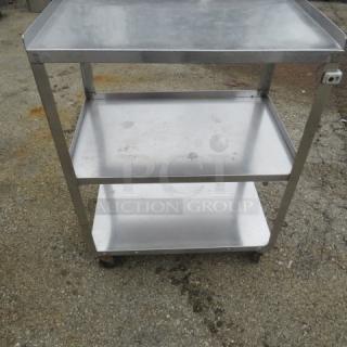 Stainless steel 3-shelf cart on casters, 24x16x32 inches. Features sturdy construction and easy mobility. Used condition.