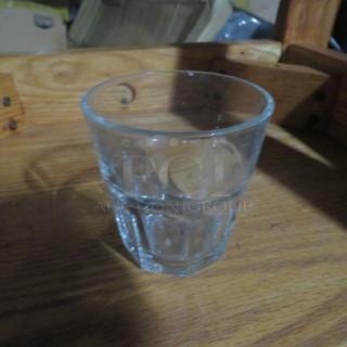 Clear glass double shot glass, faceted design, used condition, no visible markings or labels.