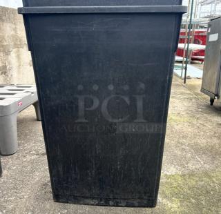 Black Slim Jim trash can, rectangular shape, used condition, slight scratches, outdoor setting.