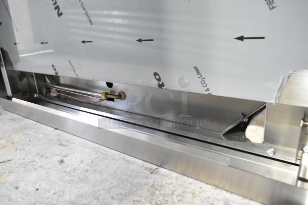 Stainless steel commercial gas range, model RC-ENR6B36TJ-NAT, featuring 6 burners, oven, backsplash, and overshelf. New condition with minor scratches and dents.