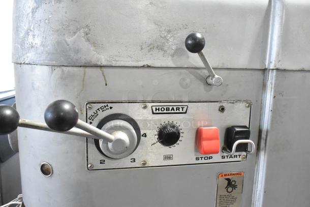 Hobart M 802 commercial dough mixer control panel with stop/start buttons and speed dial, showing signs of wear.