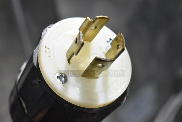 Close-up of a 230V, 3-phase power plug for a Hobart M 802 commercial mixer, showing brass prongs and white base.
