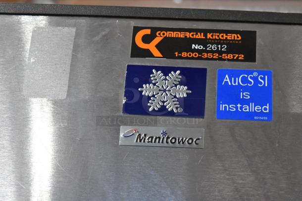 Manitowoc SD1802A stainless steel commercial ice head on bin. Labels indicate commercial installation and AuCS SI system.