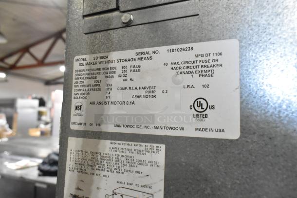 Manitowoc SD1802A stainless steel commercial ice head on bin; 208-230 volts, 1 phase. Visible label details model specs.