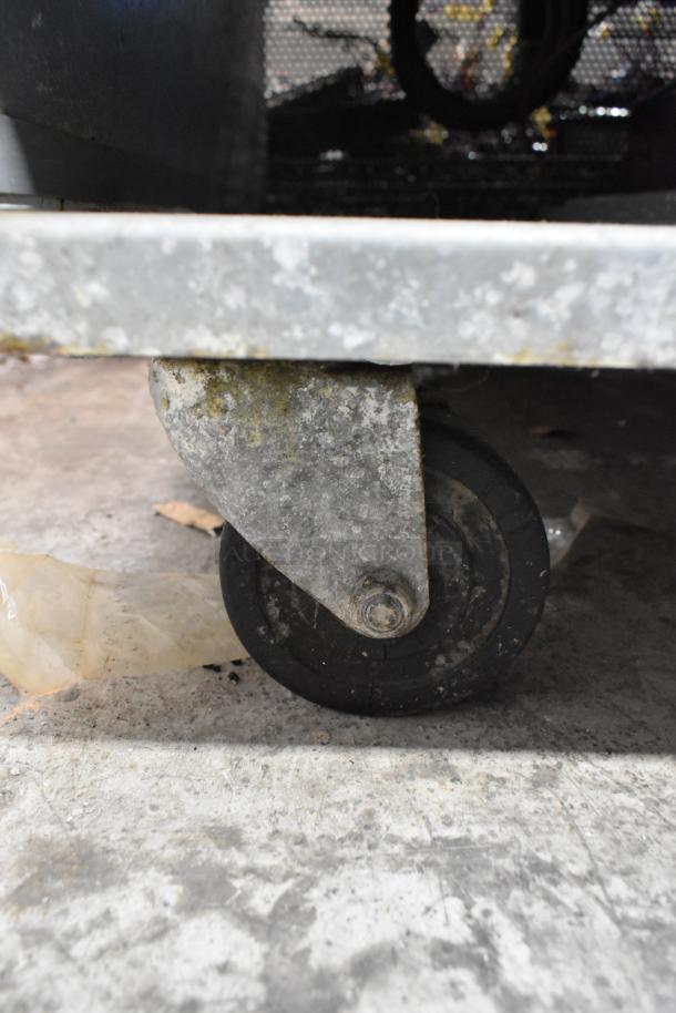 Worn commercial caster wheel of Avantco 178A49FHC stainless steel freezer, showing signs of use.