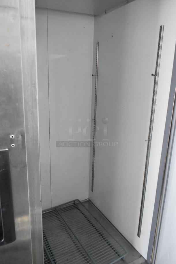 Avantco 178A49FHC stainless steel commercial 2-door reach-in freezer interior with poly-coated rack, on casters.