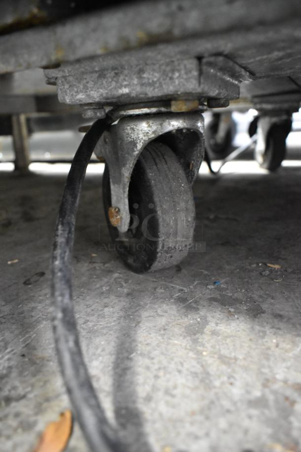 Arctic Air AR49E cooler caster, showing wear. Commercial grade wheel with visible dirt and light rust, attached to the cooler base.