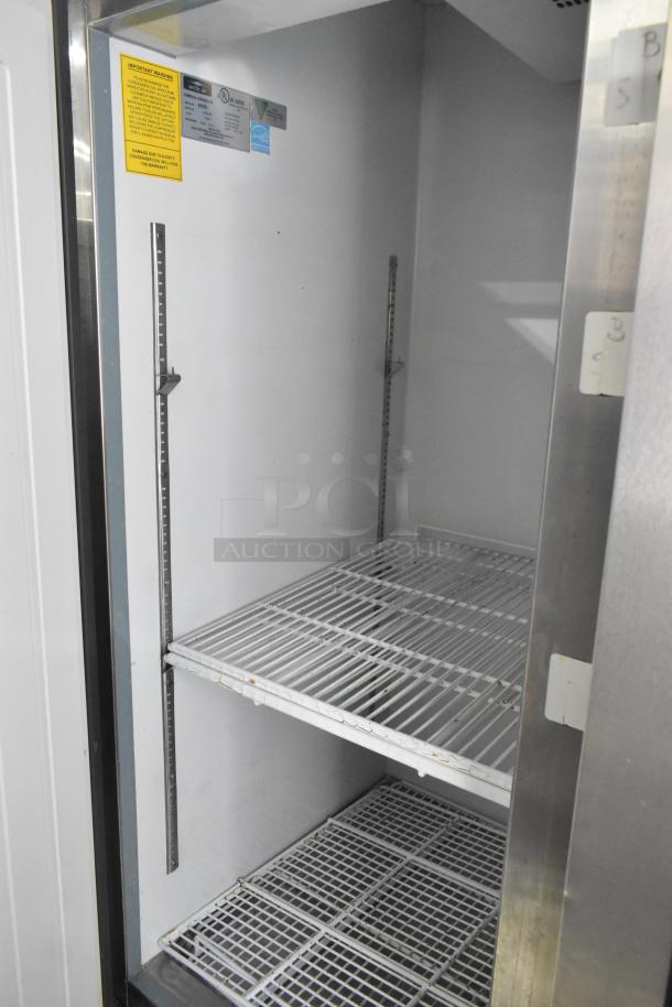 Arctic Air AR49E stainless steel 2-door reach-in cooler with poly coated rack. Visible tags with model and safety info.