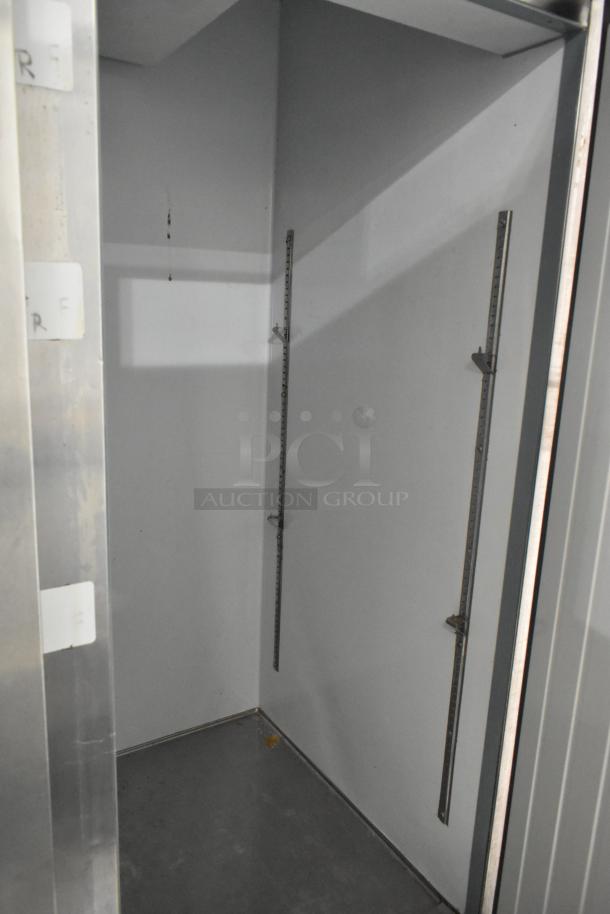 Arctic Air AR49E stainless steel commercial cooler interior, empty with poly-coated rack, on commercial casters.