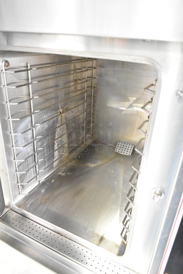 Market Forge EJ-10E stainless steel steam cabinet interior. Shows shelves and slight wear, model details not visible.