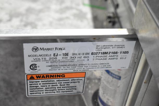 Market Forge EJ-10E Steam Cabinet, stainless steel, 2 decks, 208V, 1/3 phase. Label shows model info and safety warnings.