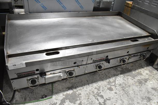 Garland stainless steel gas-powered griddle, commercial countertop model, features four control knobs, fair condition, visible use marks.