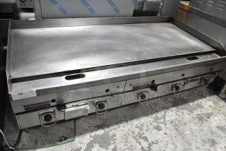 Garland stainless steel gas-powered griddle, commercial countertop model, features four control knobs, fair condition, visible use marks.