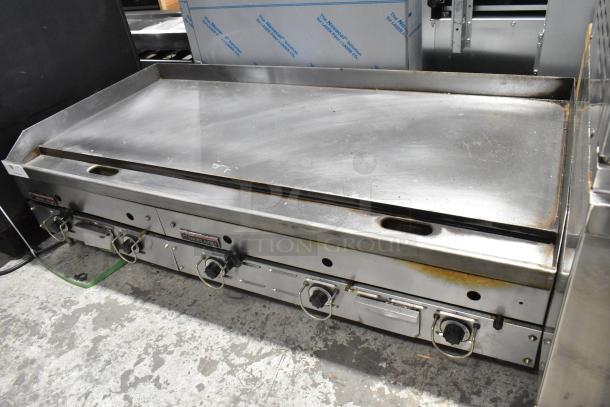 Garland stainless steel commercial gas griddle, countertop model, three burners, gently used, visible control dials.