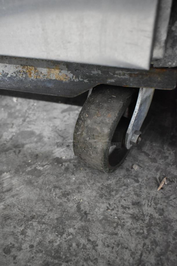 McCall PTA-3 stainless steel commercial pizza prep table with commercial casters. Visible wear, 115 volts, 1 phase.